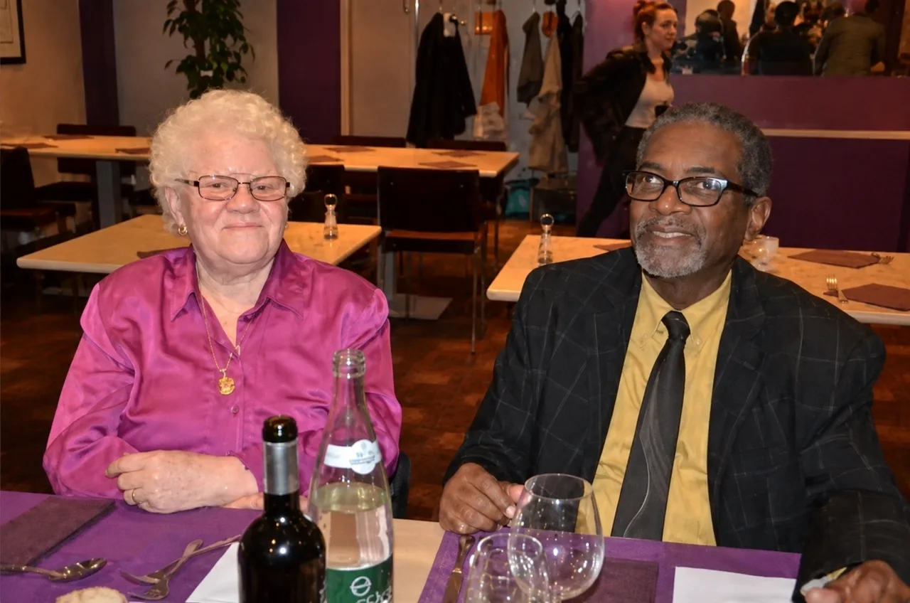 Daniel Theault en costume, assis à une table lors d’une soirée de gala.