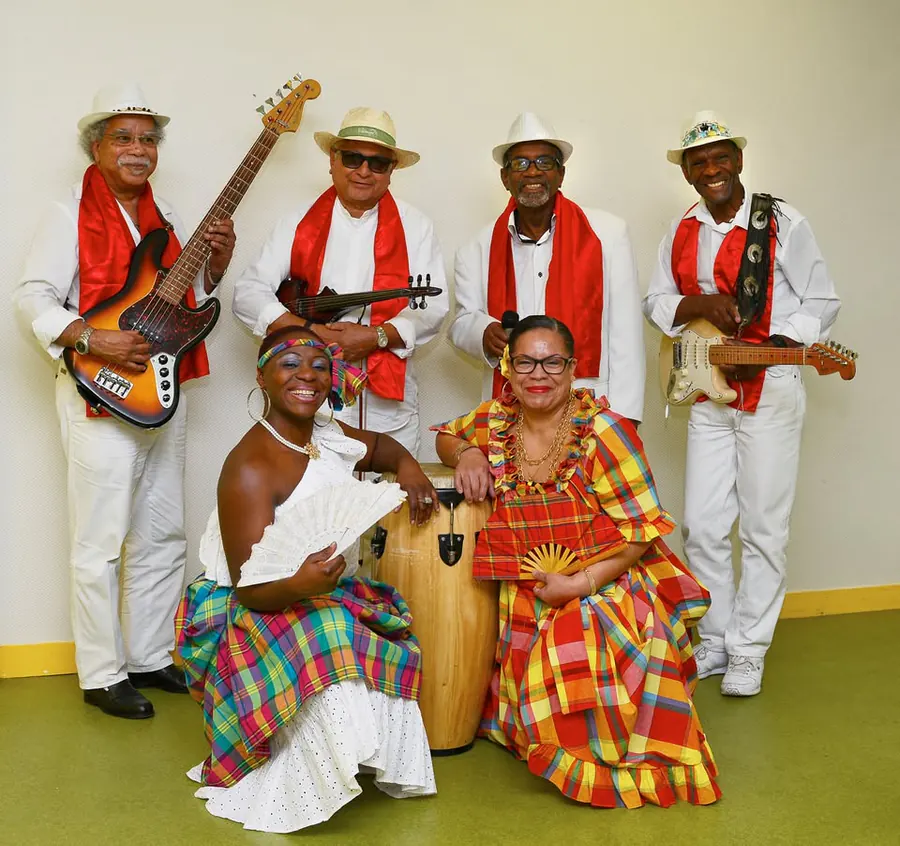 Groupe musical réuni autour de Daniel Theault, avec instruments et tenues de scène.